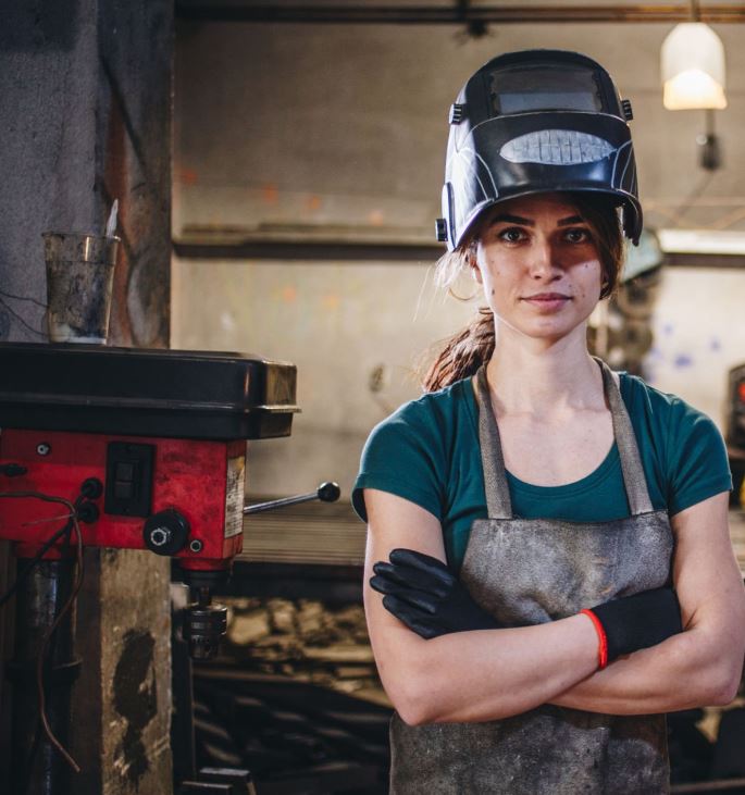 Woman welder in the workshop — employment law support from Grund